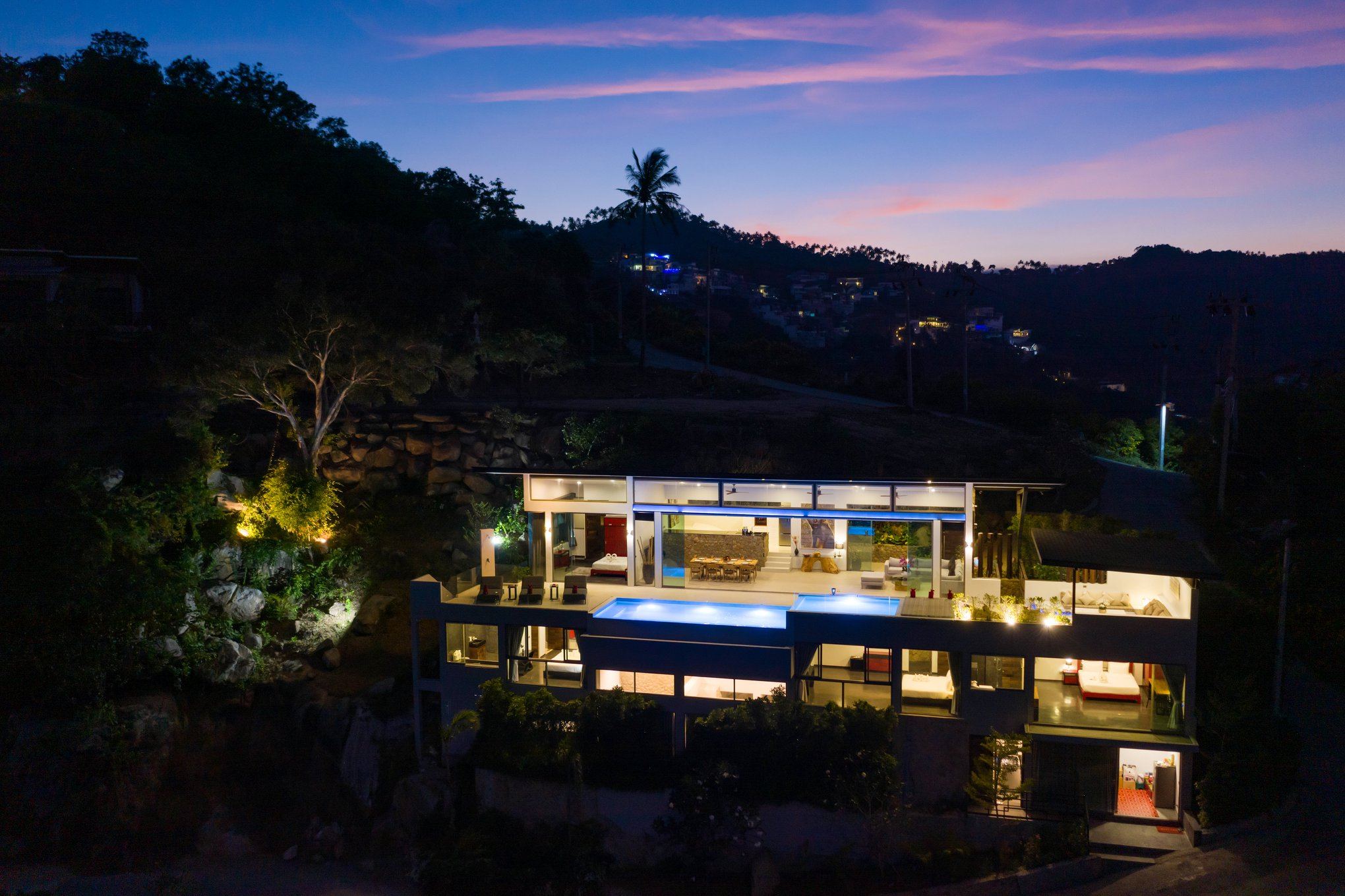 Villa 369 aerial drone view at night, all three levels illuminated, Chaweng Noi hillside
