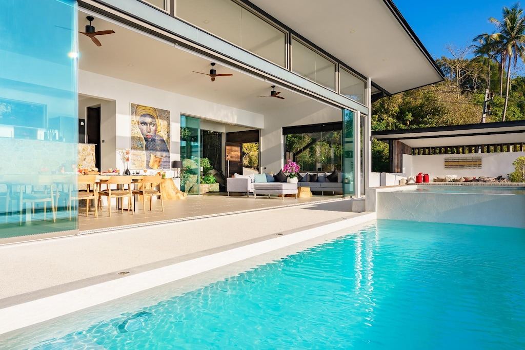 Villa 369 blue hour exterior with illuminated pool stretching toward ocean, Koh Samui